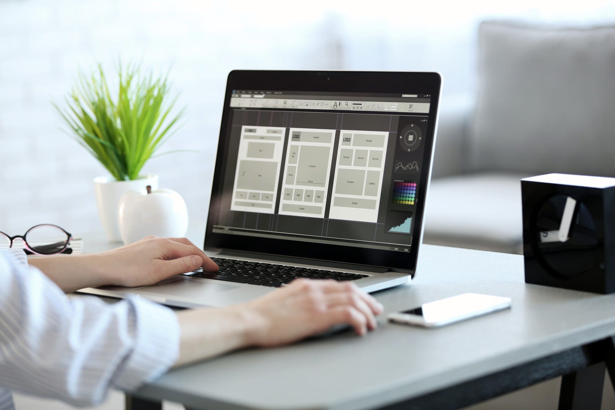 Osoba pracuje na laptopie z otwartym programem do projektowania